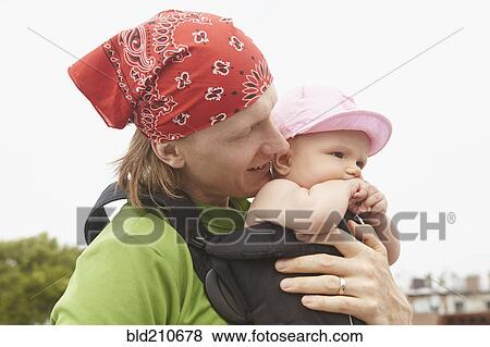 Stock Photo - Father carrying baby outdoors. Fotosearch