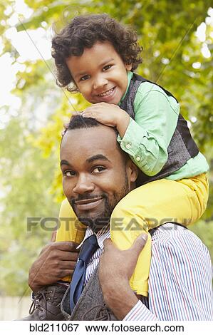 Stock Photo - Father carrying son in park. Fotosearch