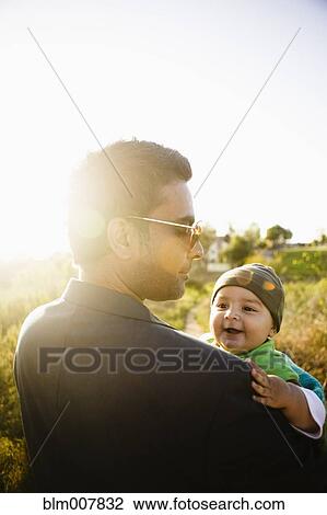 Father holding baby in field View Large Photo Image Stock Image - Father holding baby in field. Fotosearch