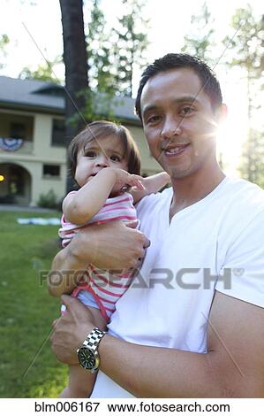 Stock Photo - Father holding daughter outdoors. Fotosearch