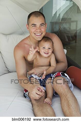 Stock Image - Father holding son on lap. Fotosearch