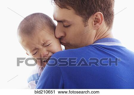 Stock Image - Father kissing crying son. Fotosearch