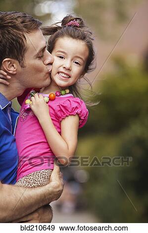 Stock Photo - Father kissing daughter on city street. Fotosearch