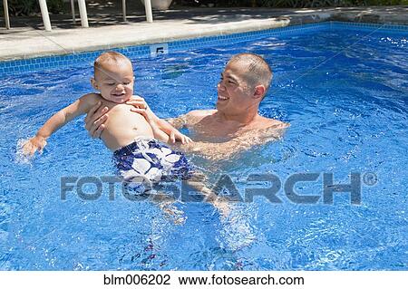 Father playing with son in swimming pool View Large Photo Image Stock Image - Father playing with son in swimming pool. Fotosearch