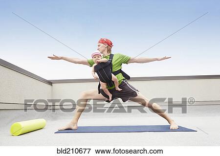 Father practicing yoga and holding baby View Large Photo Image Stock Photo - Father practicing yoga and holding baby. Fotosearch