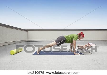 Stock Photography - Father practicing yoga and talking to baby. Fotosearch