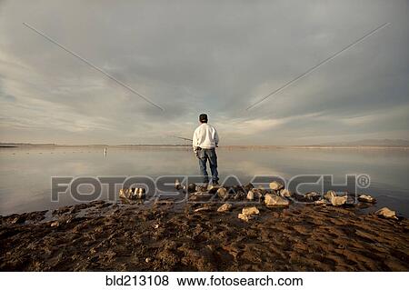 Stock Photo - Fisherman at dry lake during drought. Fotosearch