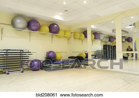 Stock Image - Fitness balls on rack in empty fitness classroom. Fotosearch