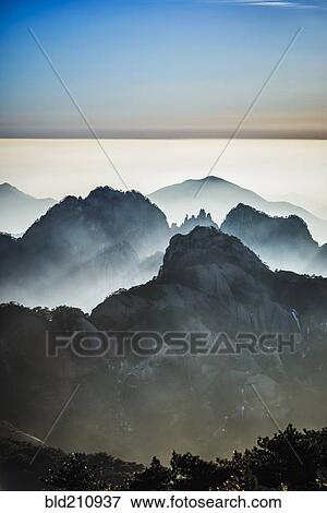Stock Photo - Fog rolling over rocky mountains, Huangshan, Anhui, China,. Fotosearch
