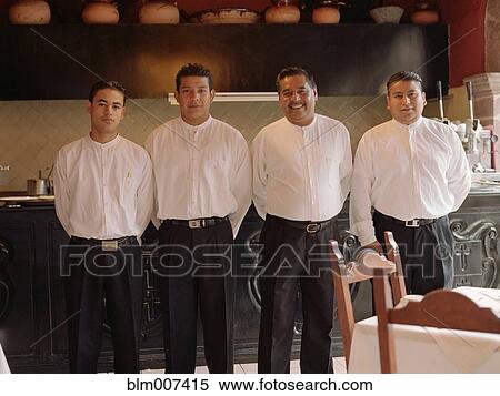 Stock Photography - Four men standing in a row in restaurant. Fotosearch