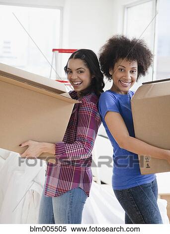 Friends carrying cardboard moving boxes View Large Photo Image Stock Photography - Friends carrying cardboard moving boxes. Fotosearch