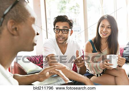 Stock Photograph - Friends hanging out at cafe. Fotosearch