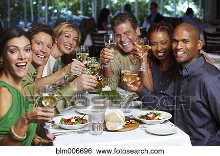 Stock Photograph - Friends having dinner in restaurant. Fotosearch