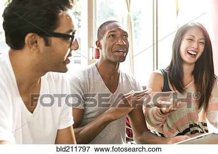 Friends laughing together in cafe View Large Photo Image Stock Photo - Friends laughing together in cafe. Fotosearch