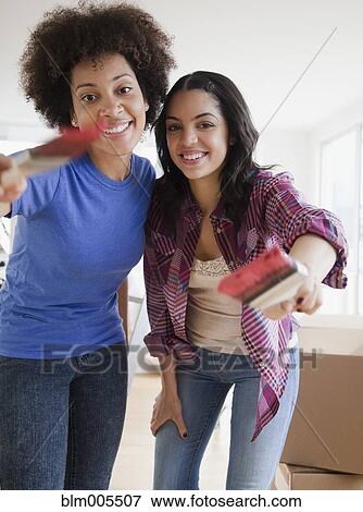 Stock Photo - Friends painting new home. Fotosearch