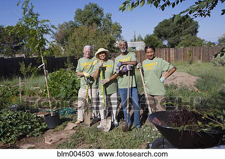 Stock Image - Friends planting community garden. Fotosearch
