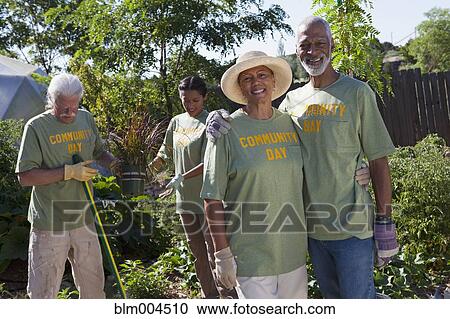 Stock Image - Friends planting community garden. Fotosearch
