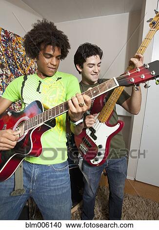 Stock Image - Friends playing guitar together. Fotosearch