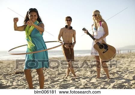 Stock Image - Friends playing on beach. Fotosearch
