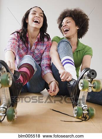 Friends putting on roller skates View Large Photo Image Stock Photo - Friends putting on roller skates. Fotosearch