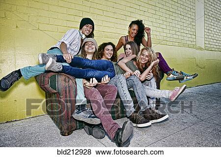 Friends relaxing on sofa on city street View Large Photo Image Stock Photo - Friends relaxing on sofa on city street. Fotosearch