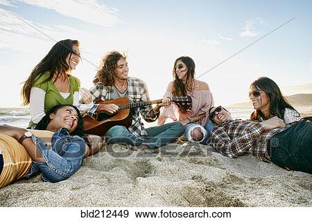 Friends relaxing together on beach View Large Photo Image Stock Photo - Friends relaxing together on beach. Fotosearch