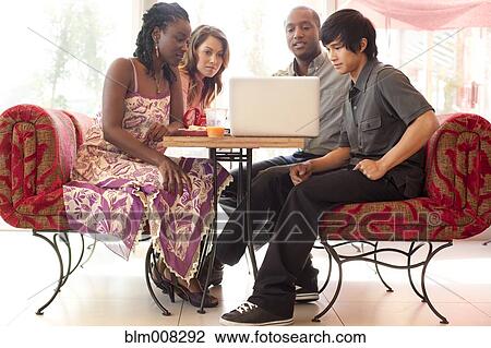 Friends sitting at laptop in cafe View Large Photo Image Stock Image - Friends sitting at laptop in cafe. Fotosearch