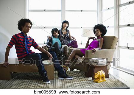 Stock Photo - Friends sitting in living room. Fotosearch