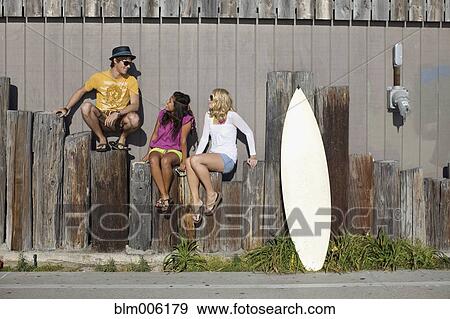 Friends sitting on posts View Large Photo Image Stock Photo - Friends sitting on posts. Fotosearch