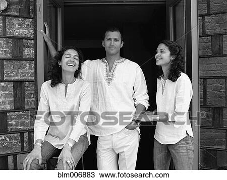 Stock Image - Friends standing in doorway. Fotosearch