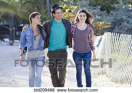 Stock Photo - Friends walking on beach. Fotosearch