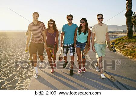 Friends walking together on beach View Large Photo Image Stock Photo - Friends walking together on beach. Fotosearch