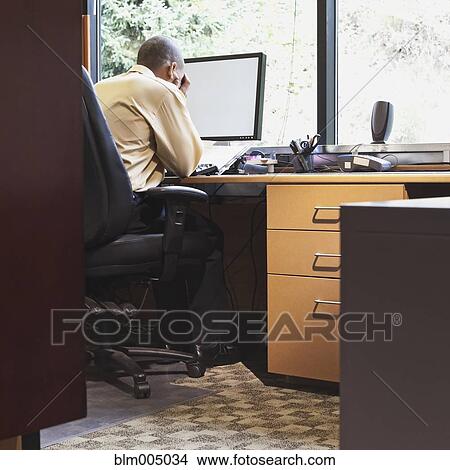 Frustrated mixed race businessman sitting at desk View Large Photo Image Picture - Frustrated mixed race businessman sitting at desk. Fotosearch