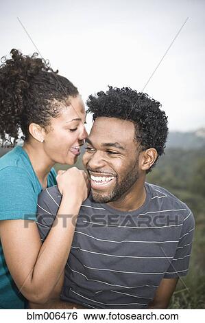 Stock Photograph - Girlfriend telling boyfriend secrets. Fotosearch