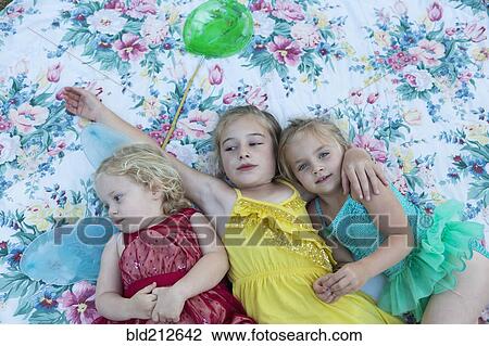 Girls laying on blanket together View Large Photo Image Stock Image - Girls laying on blanket together. Fotosearch