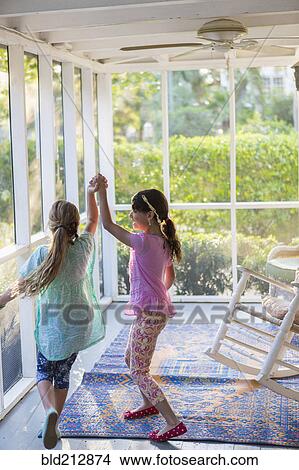 Picture - Girls playing together on porch. Fotosearch