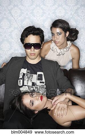 Stock Photo - Glamorous people sitting on sofa. Fotosearch