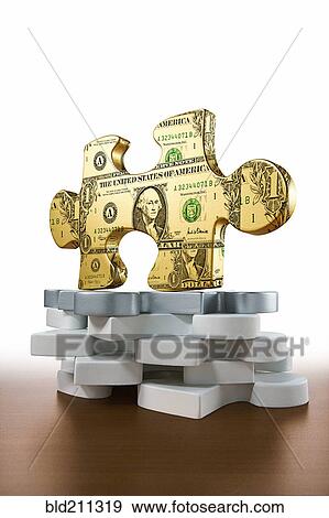 Stock Photo - Gold piece of jigsaw puzzle printed with dollars. Fotosearch