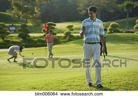 Golfer text messaging on cell phone View Large Photo Image Picture - Golfer text messaging on cell phone. Fotosearch