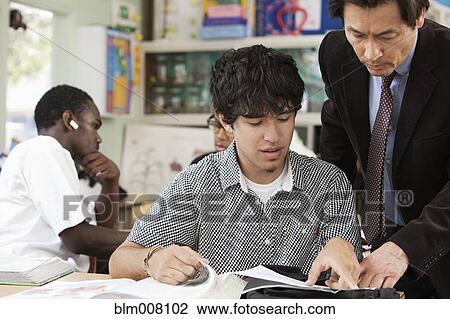 Stock Image - High school student listening to teacher. Fotosearch