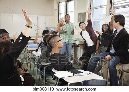 Stock Image - High school students answering questions in classroom. Fotosearch