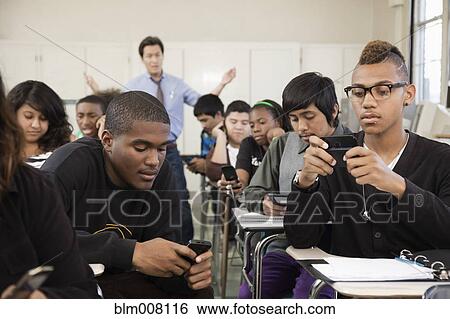 High school students using cell phones in classroom View Large Photo Image Stock Photograph - High school students using cell phones in classroom. Fotosearch