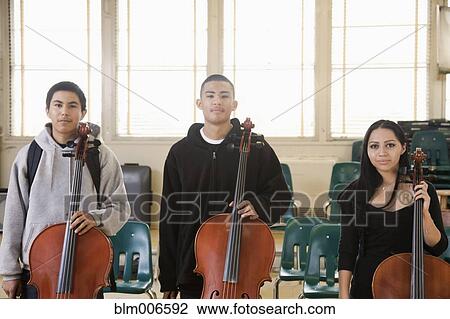 Stock Image - High school students with cellos in orchestra. Fotosearch