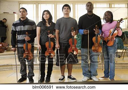 Stock Image - High school students with violins in orchestra. Fotosearch