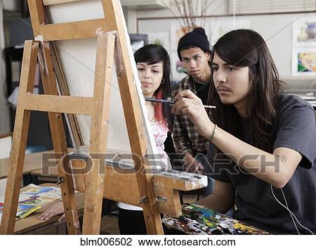 Stock Image - Hispanic artist painting in art class. Fotosearch