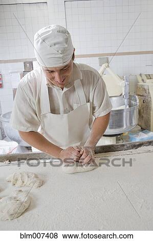 Stock Photo - Hispanic baker kneading dough. Fotosearch