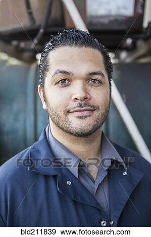 Stock Photo - Hispanic blue collar worker smiling outdoors. Fotosearch