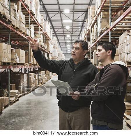 Hispanic boss talking to worker in warehouse View Large Photo Image Stock Photo - Hispanic boss talking to worker in warehouse. Fotosearch