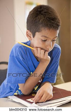 Stock Image - Hispanic boy doing homework. Fotosearch