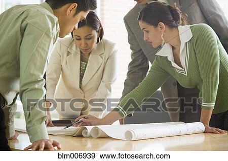 Stock Photo - Hispanic business people looking at blueprints. Fotosearch
